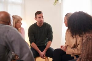 a person talks to a group about how family therapy helps