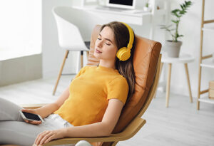 a person sits in a chair with headphones on during music therapy